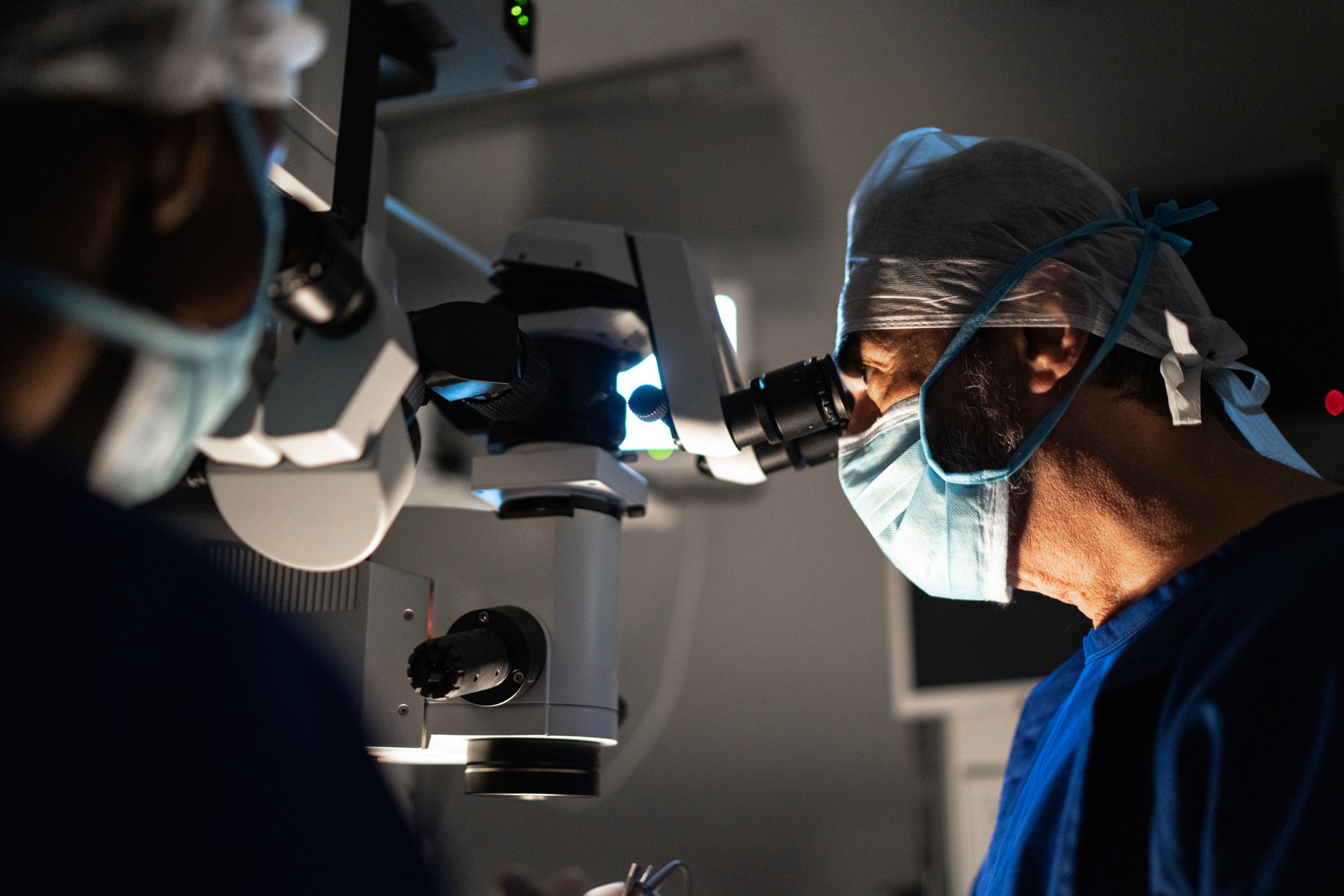 two eye surgeons look into scopes