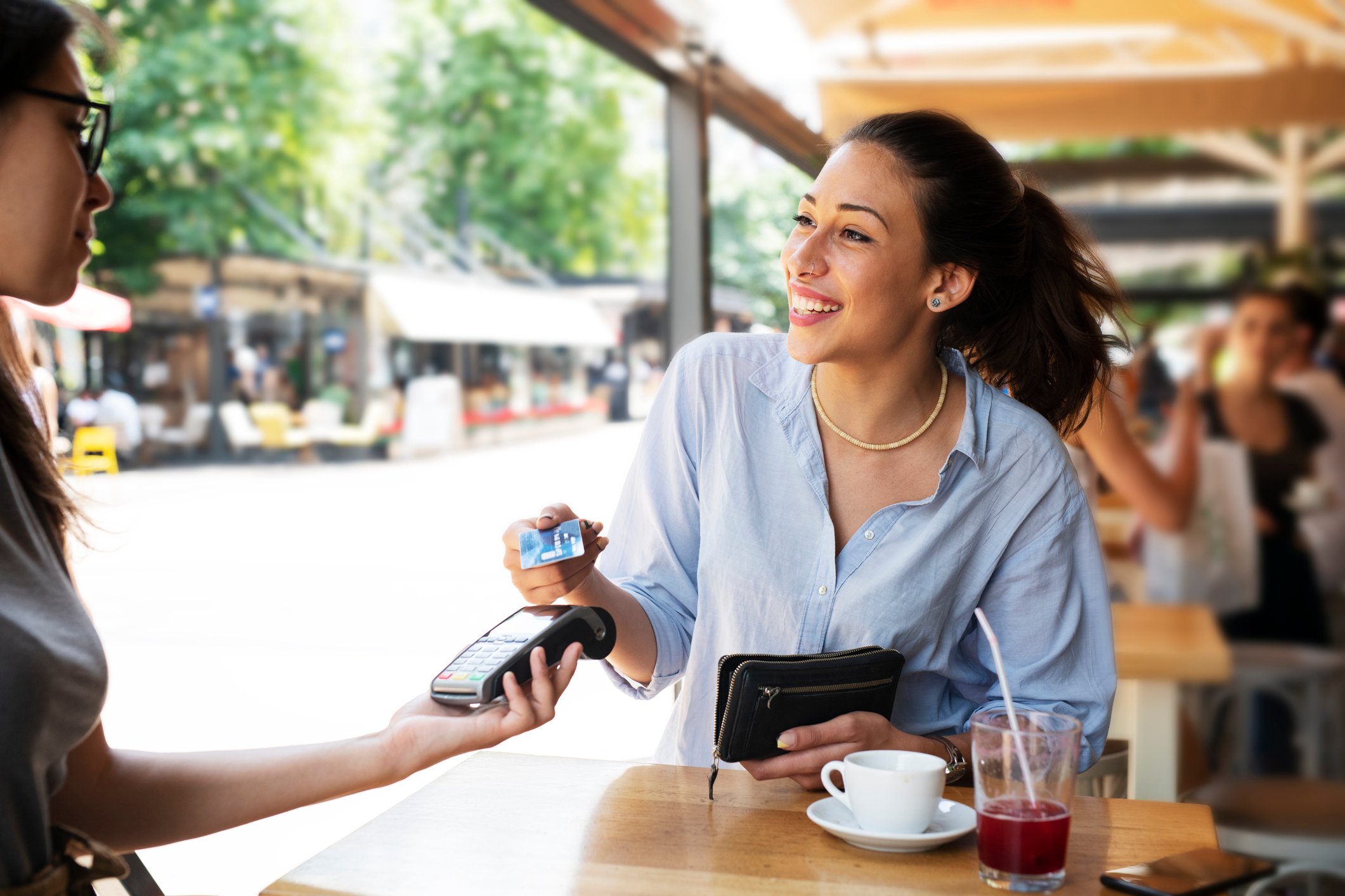Person paying with card at cafe.