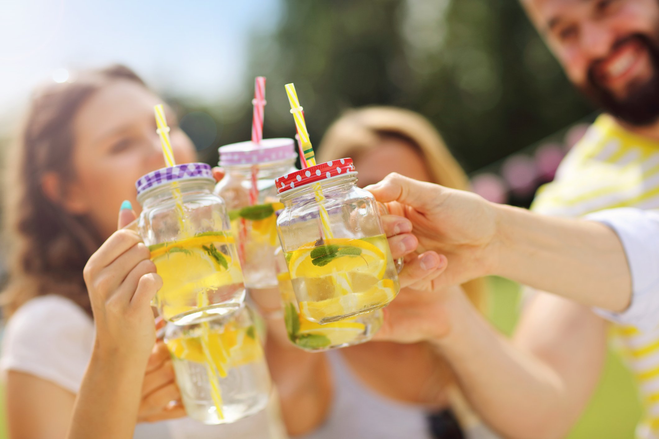 Four people are toasting using jars of Lemonade.