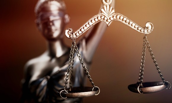 Statue of Justice holding balanced scales.