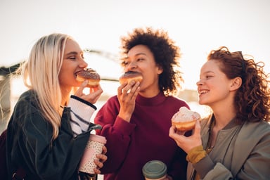 Three friends eating doughnuts
