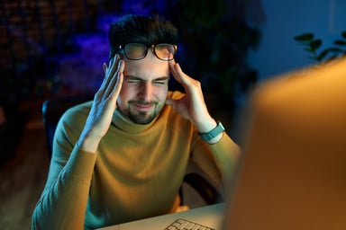 Businessperson rubbing their temples and frowning