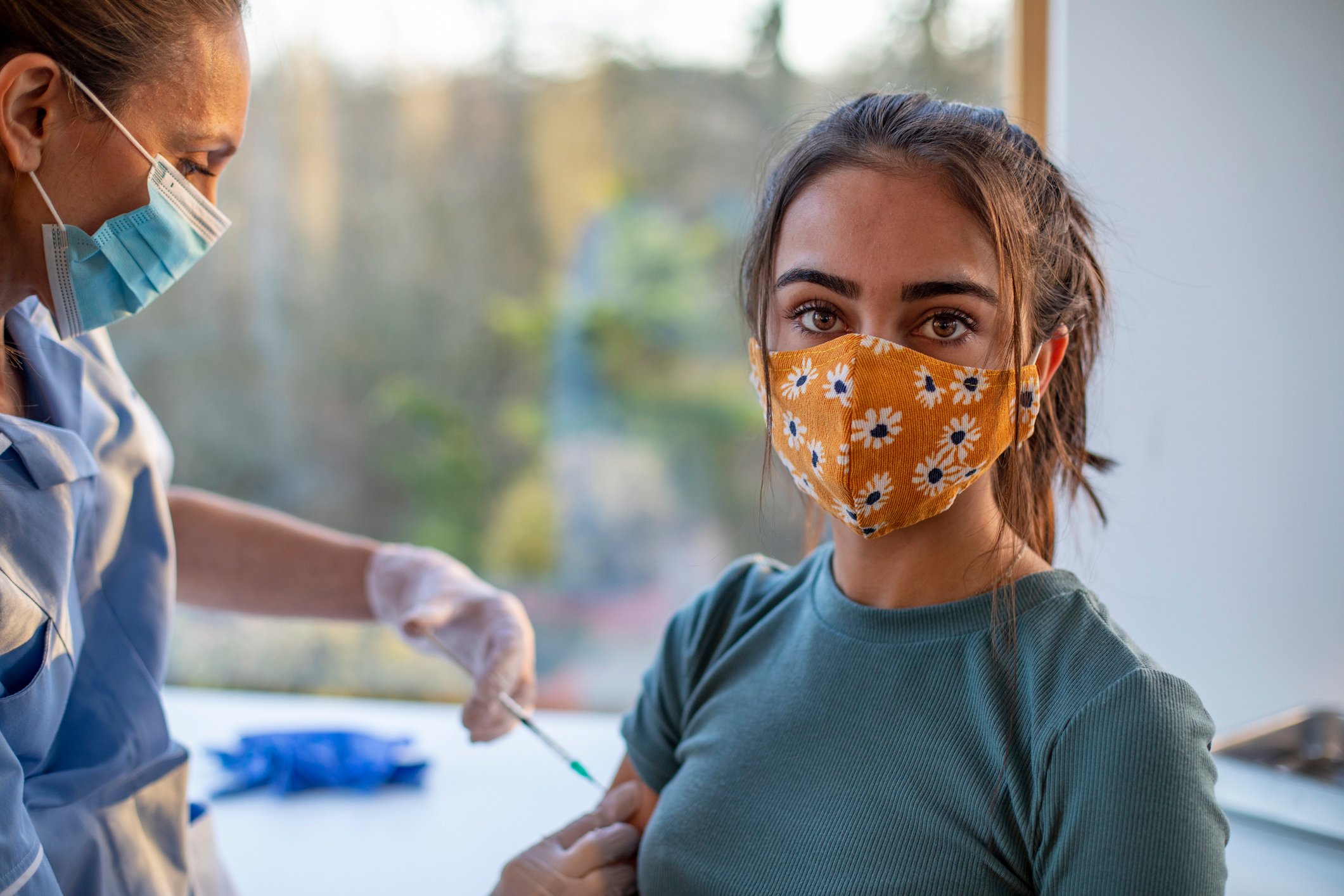 A healthcare professional giving a vaccine shot to a person.
