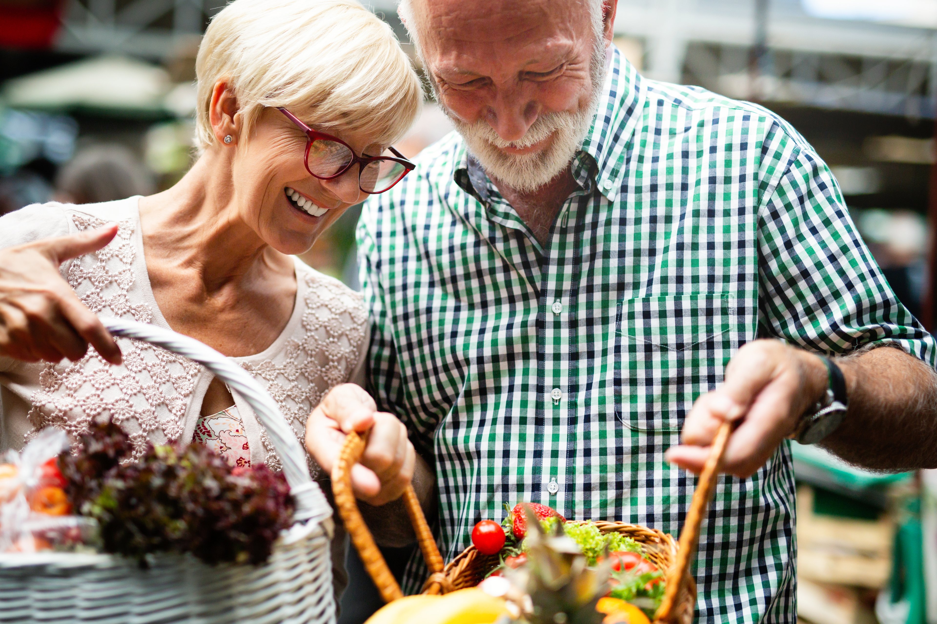 Two people looking at flowers in a basket.