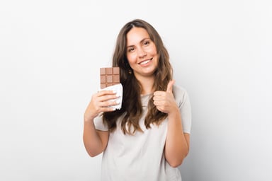 A person happily holds a chocolate bar