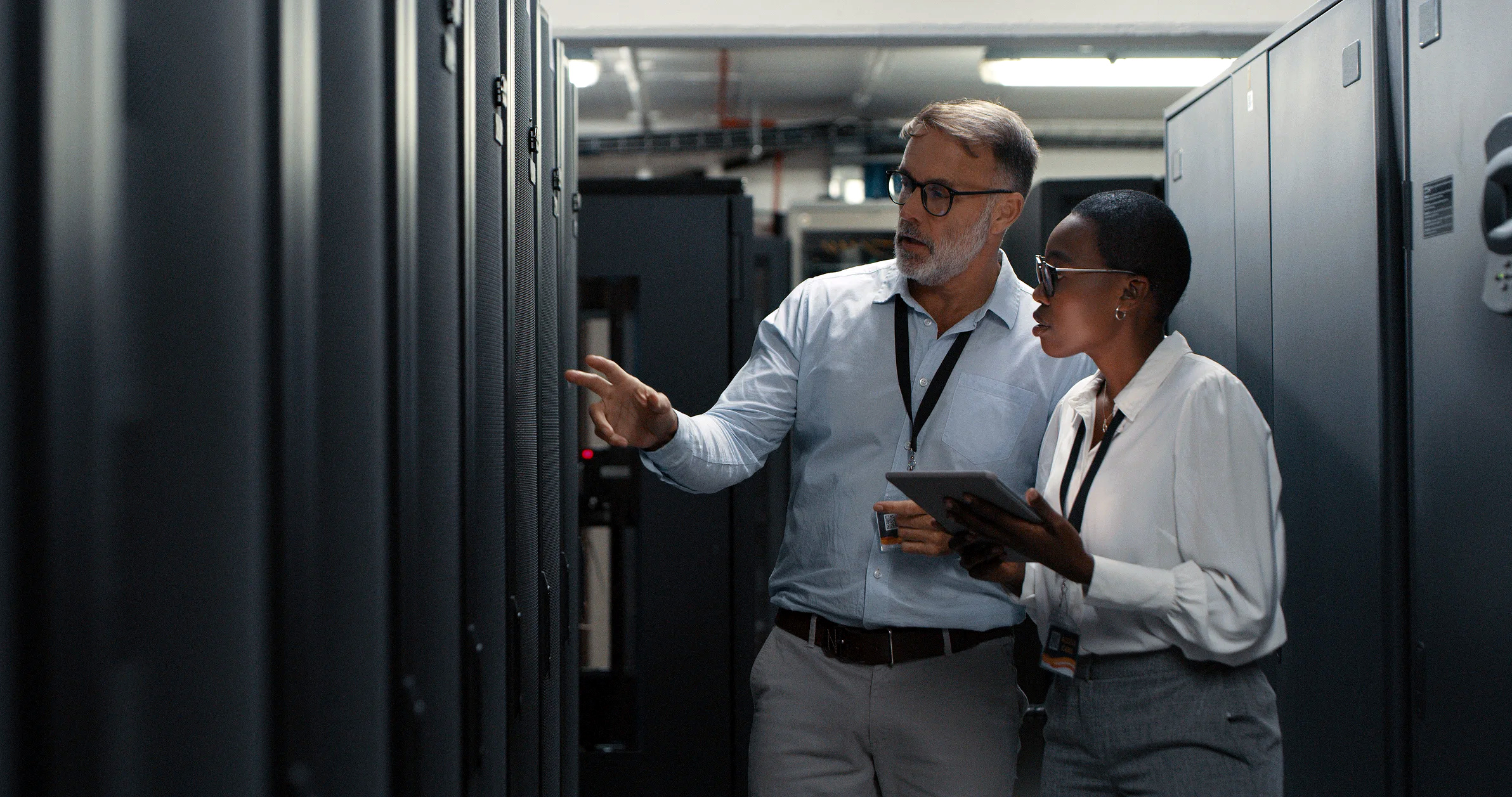 Two people working in a data center.
