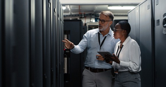 Two people working in a data center.