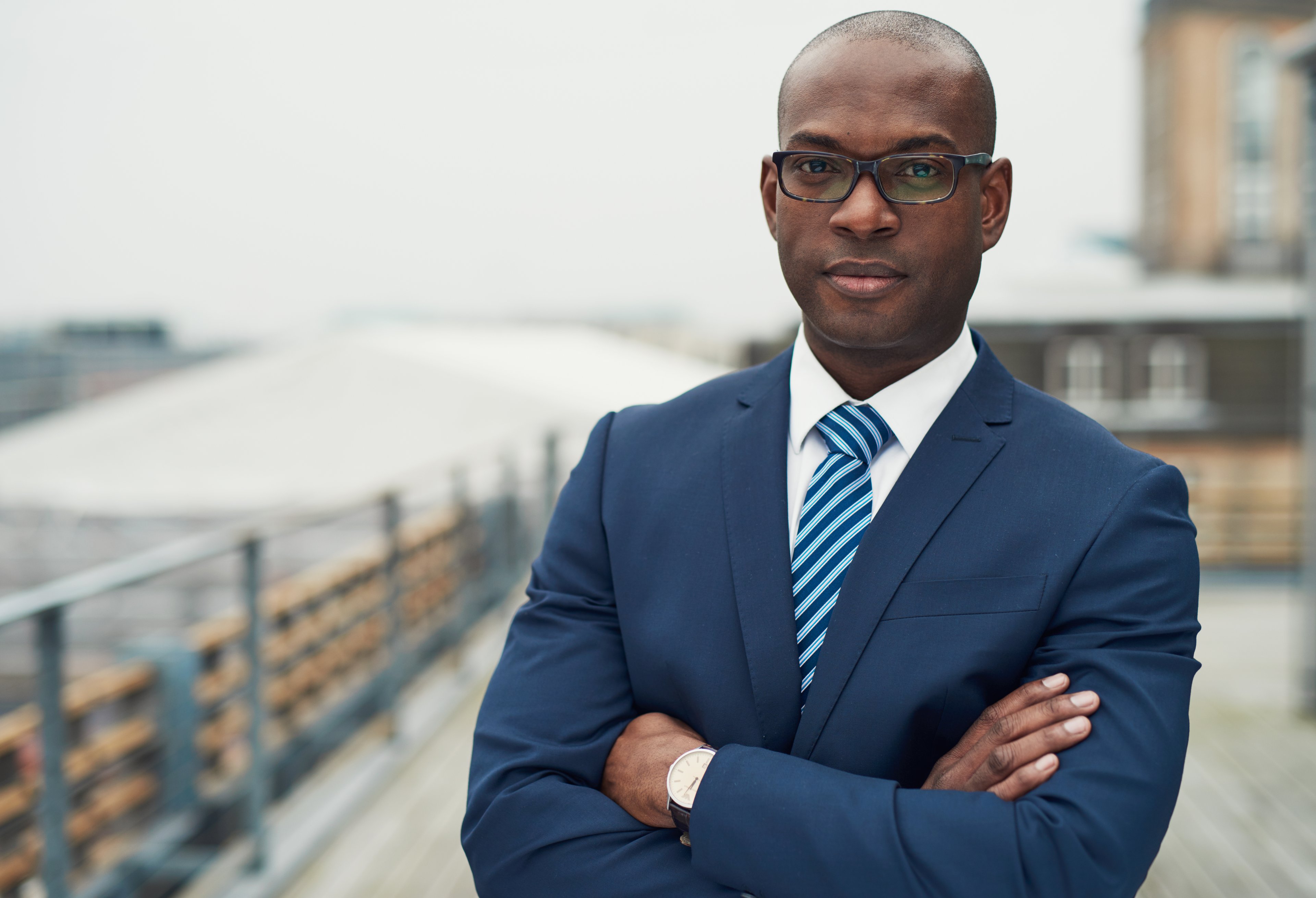 Business professional in suit and tie standing outside.