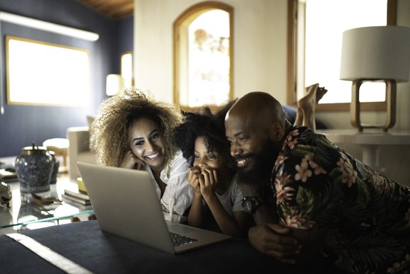 Family looking at laptop screen.