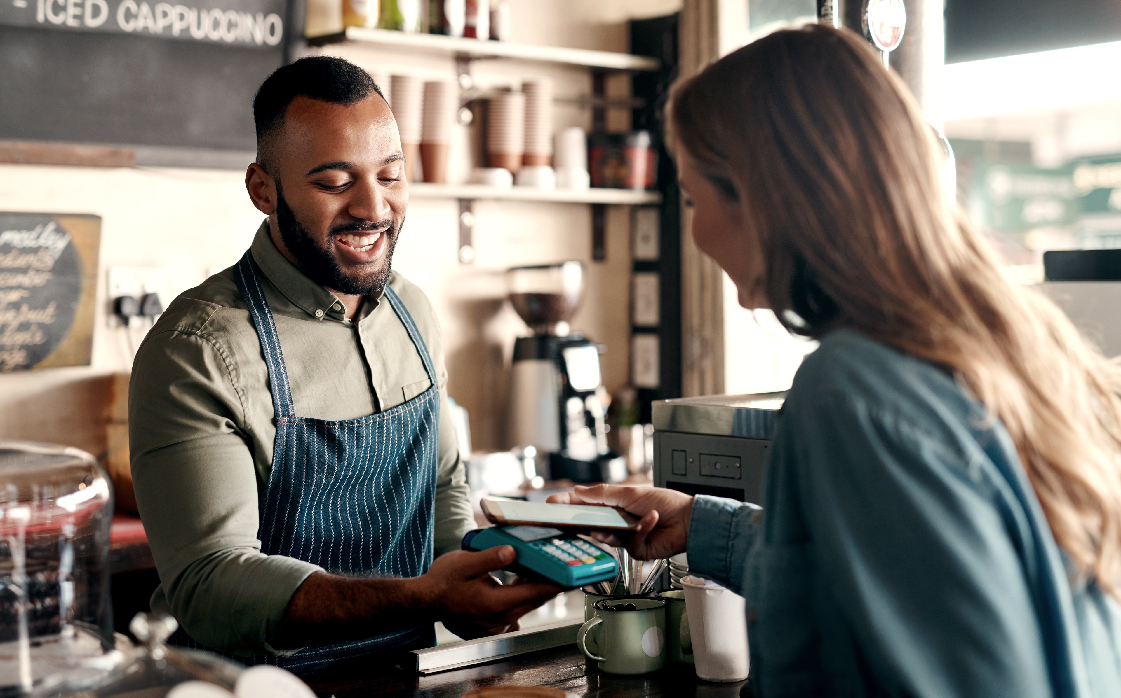 A customer using a smartphone to make a contactless payment.