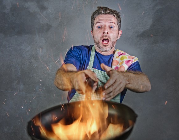 Man with frying pan on fire.