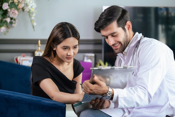Two people looking at a clipboard.