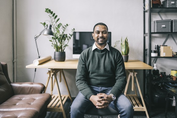 Person sitting at desk and smiling.
