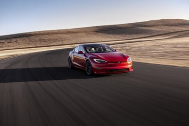 A Tesla driving on a desert road.