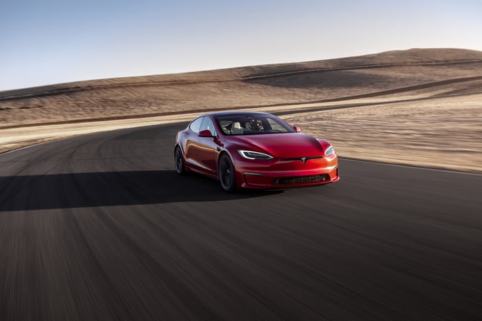 A Tesla Model S driving on a desert road.