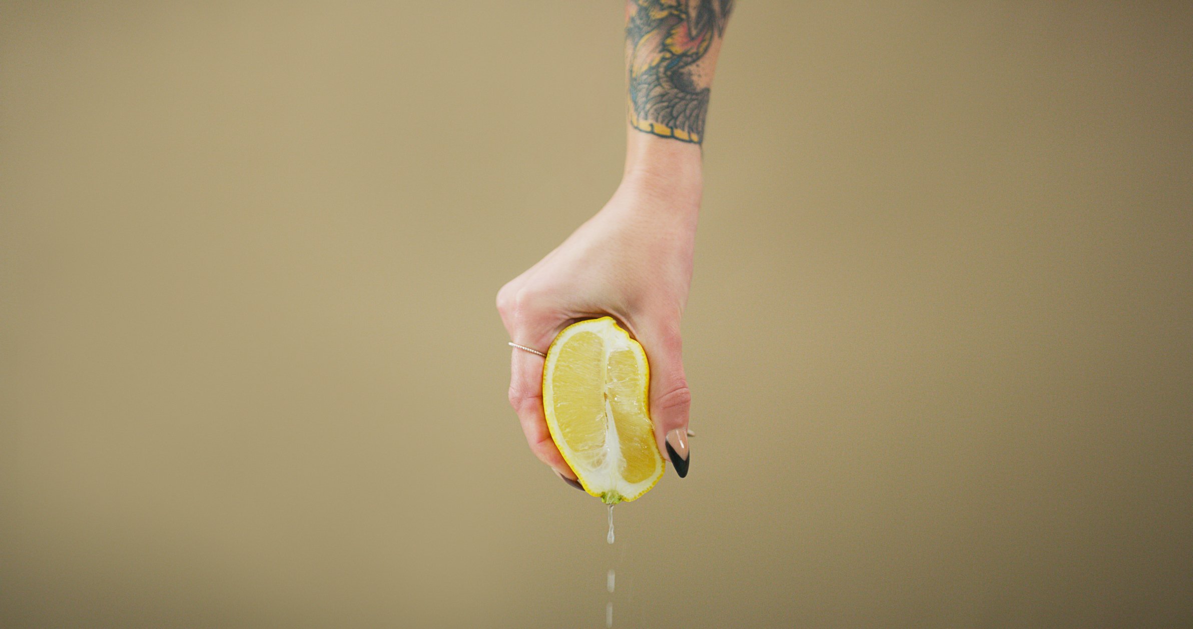 Close up of a hand squeezing a lemon