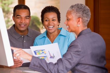 People reviewing financials on a screen.