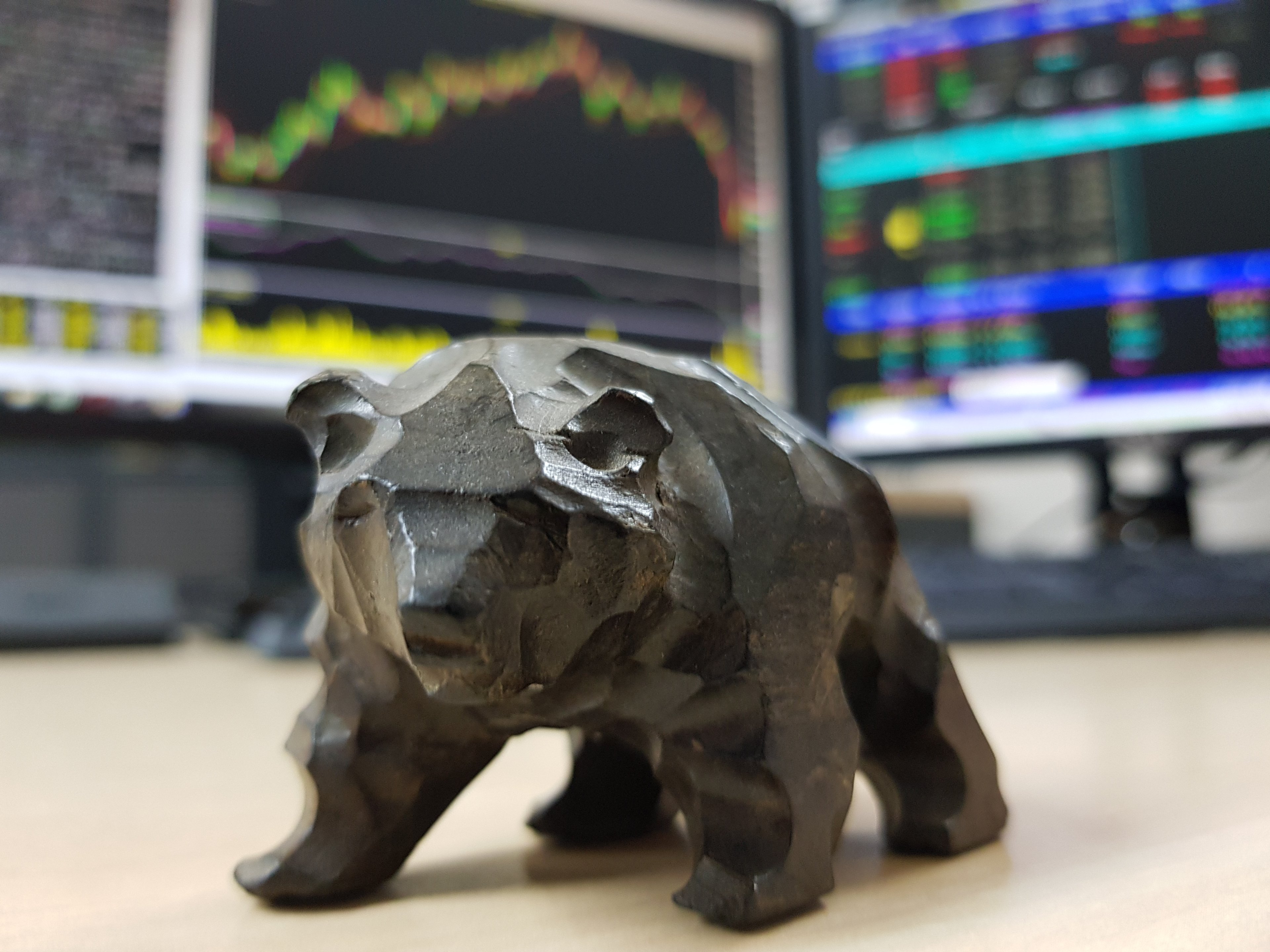 bear in front of stocks on screen
