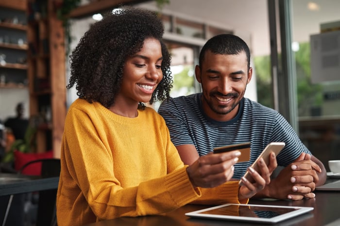 Couple with credit card and mobile devices.