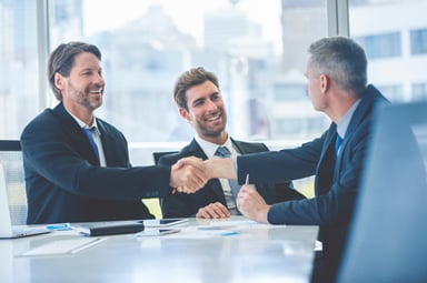 two people shaking hands at a business meeting