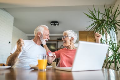 couple cheers good news by laptop