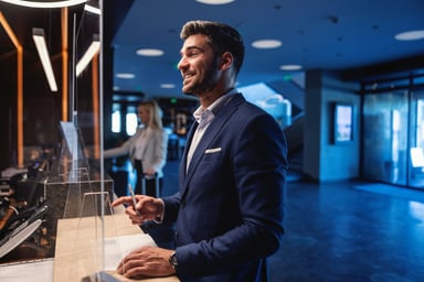 Happy business person at hotel reception.
