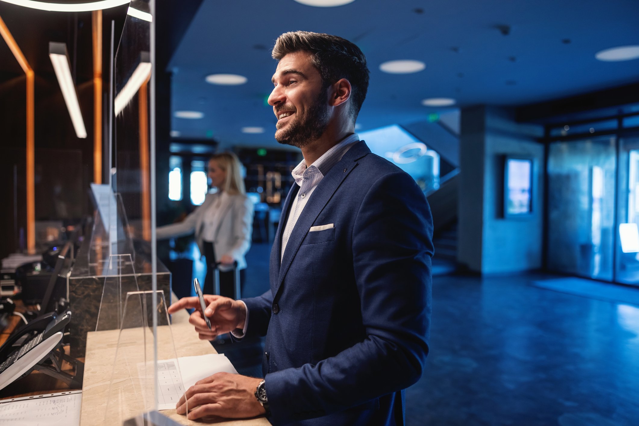 Happy business person at hotel reception.