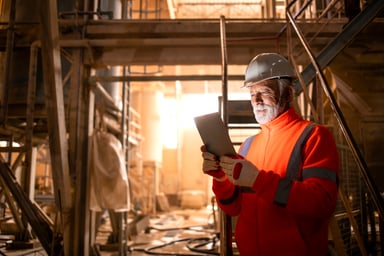 a worker reads a tablet in an underground mine.