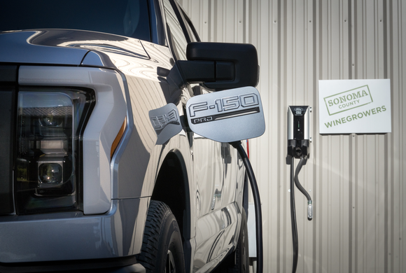 Ford F-150 Lightning plugged into charger. 