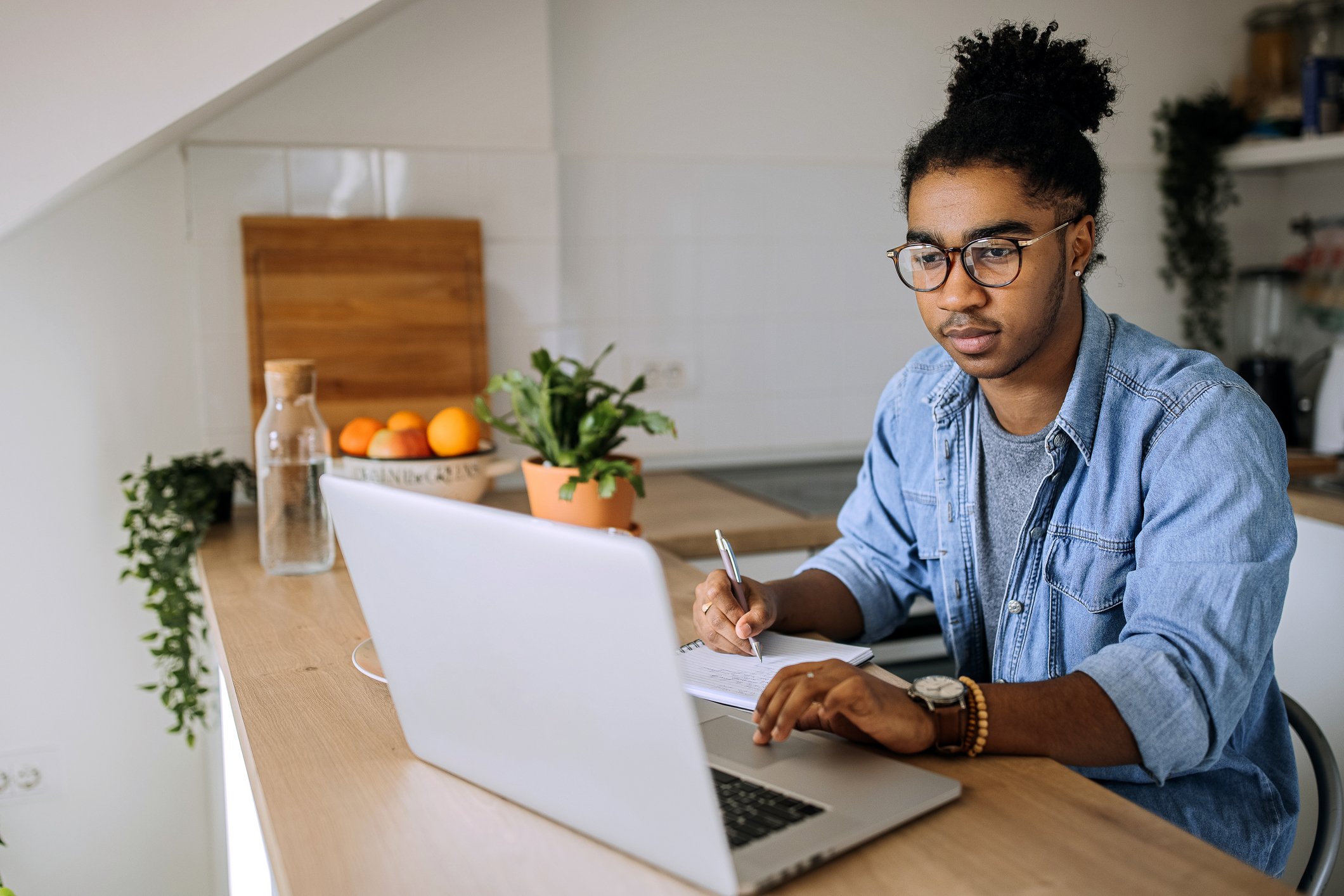 A person sits at a desk and uses a laptop.