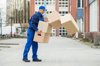 Delivery man dropping a stack of boxes.