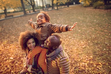 People playing in fall leaves