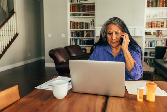 Person sitting at table looking at computer.