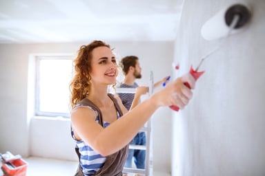 home improvement_two people smiling painting wall
