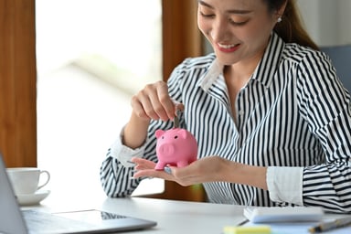 saver puts money in piggy bank