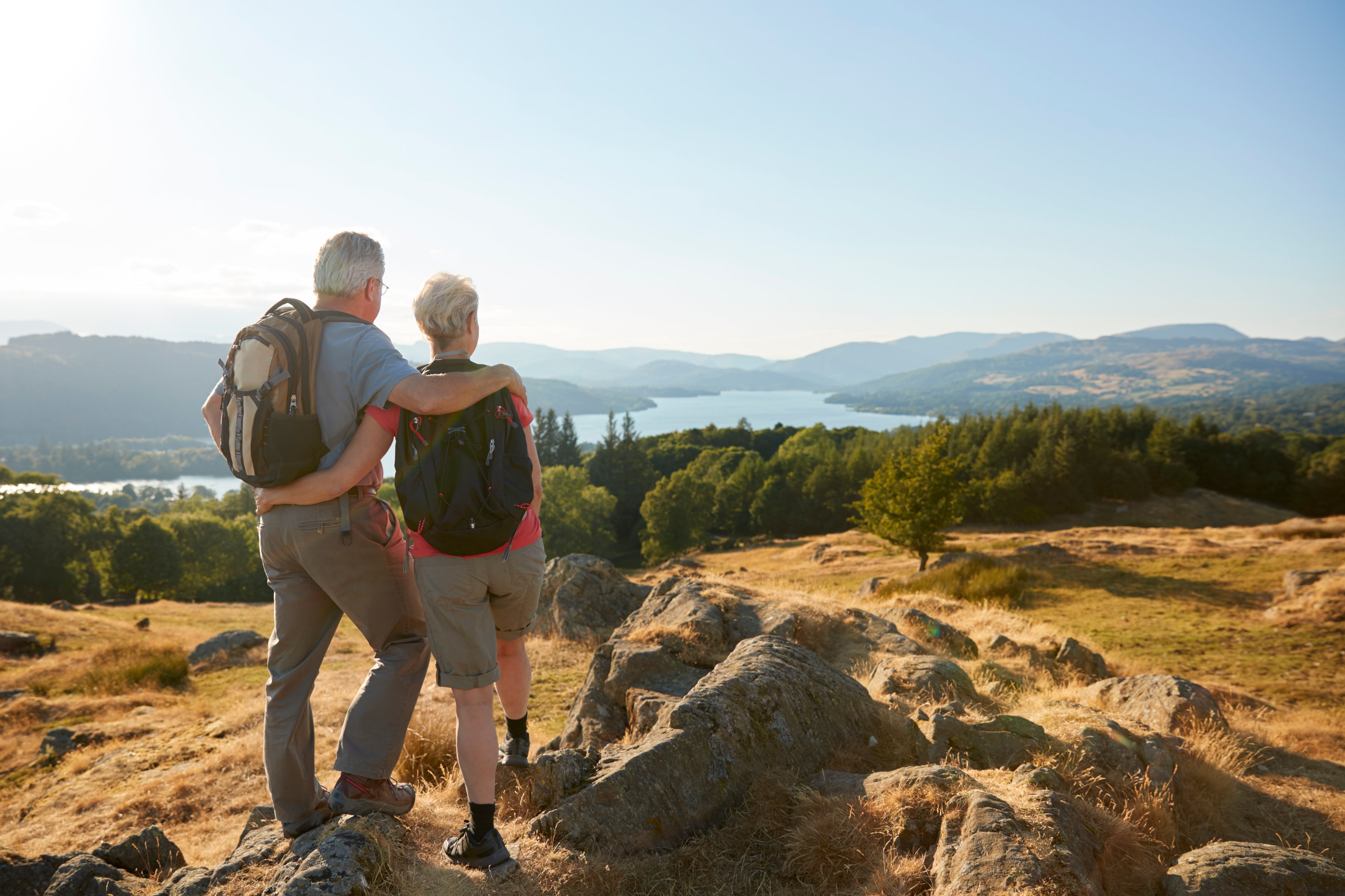 Two people embracing each other while taking in a scenic view. 