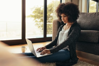 Person sitting on floor using laptop