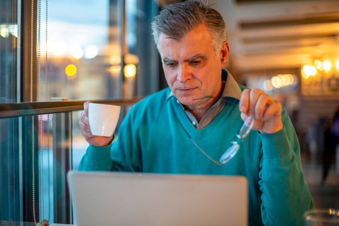 A person with a serious expression at a laptop.