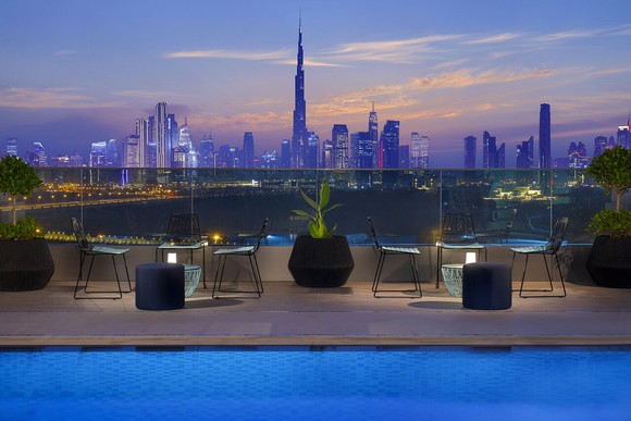 A Dubai cityscape at dusk, seen from the pool area of a Marriott hotel.