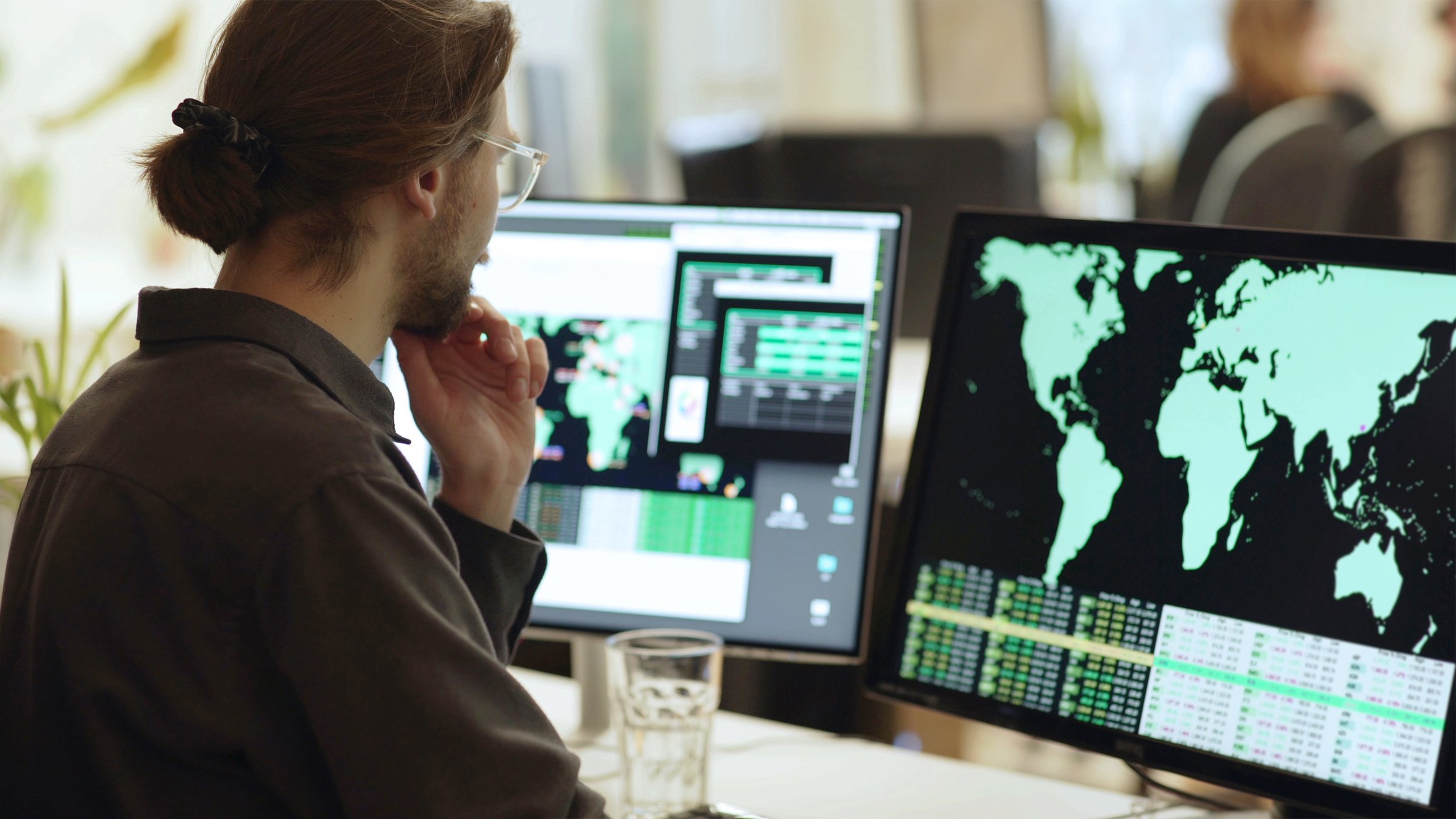 A person looking at data on screens.