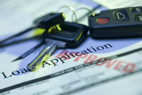 Car keys sitting on an auto loan approval form