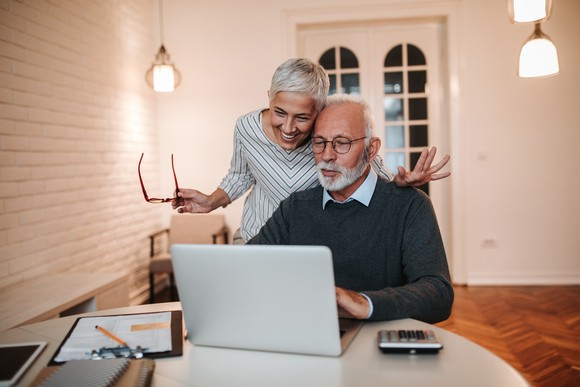 Two people looking at a laptop.