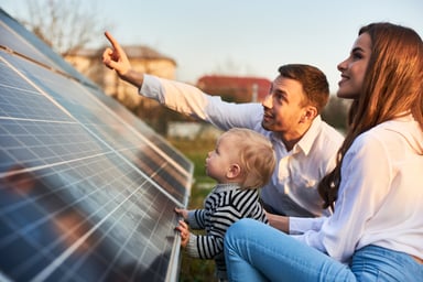 A couple with a toddler viewing solar panels