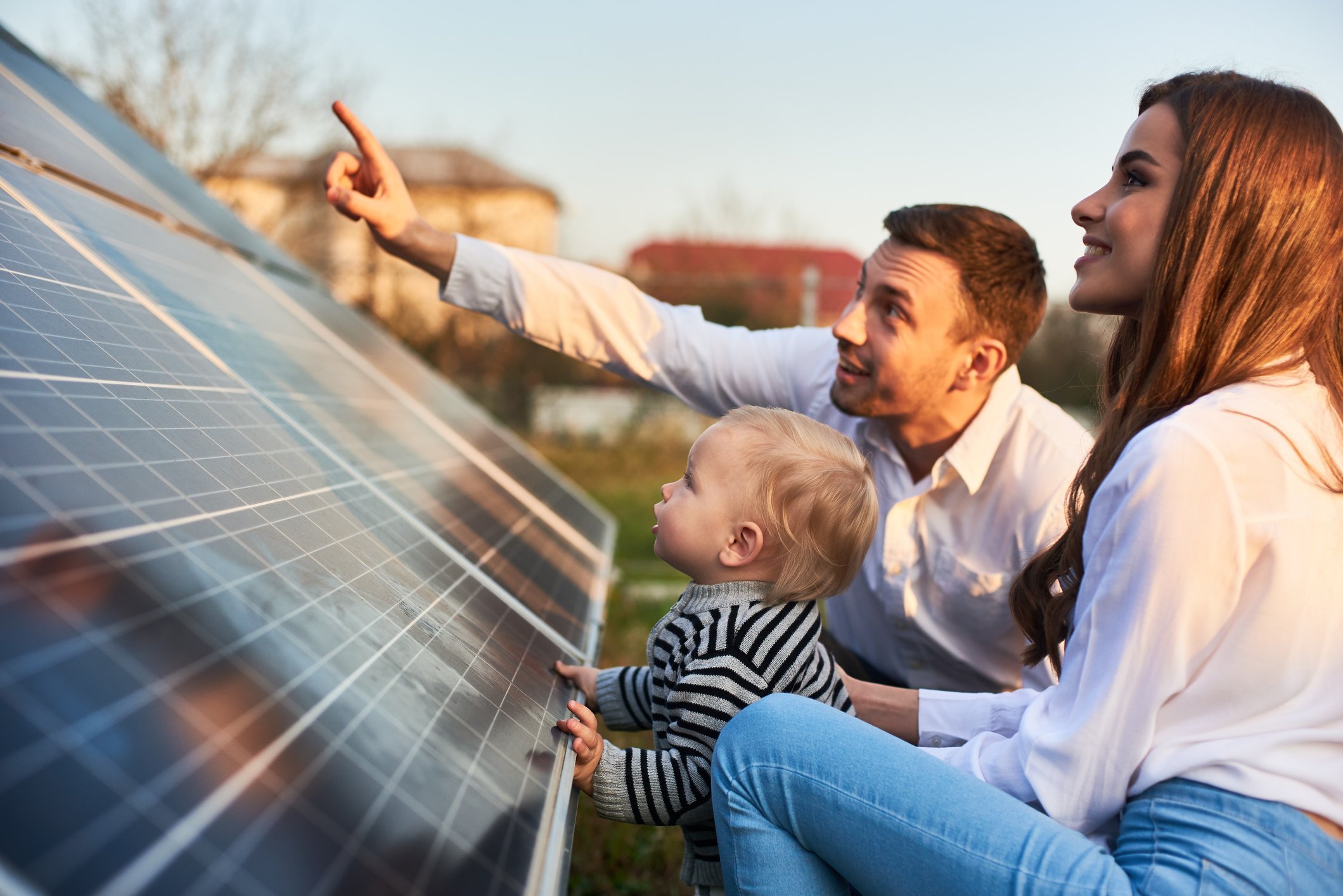 A couple with a toddler viewing solar panels