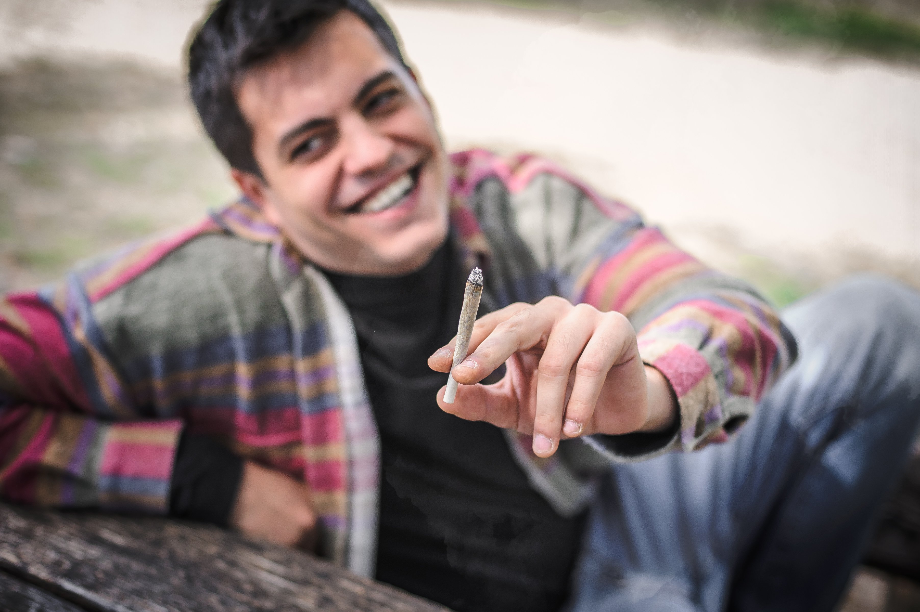 marijuana user smiling smoking a joint.