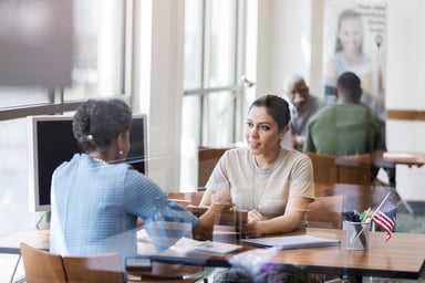 A consumer at a banker's desk applying for a loan