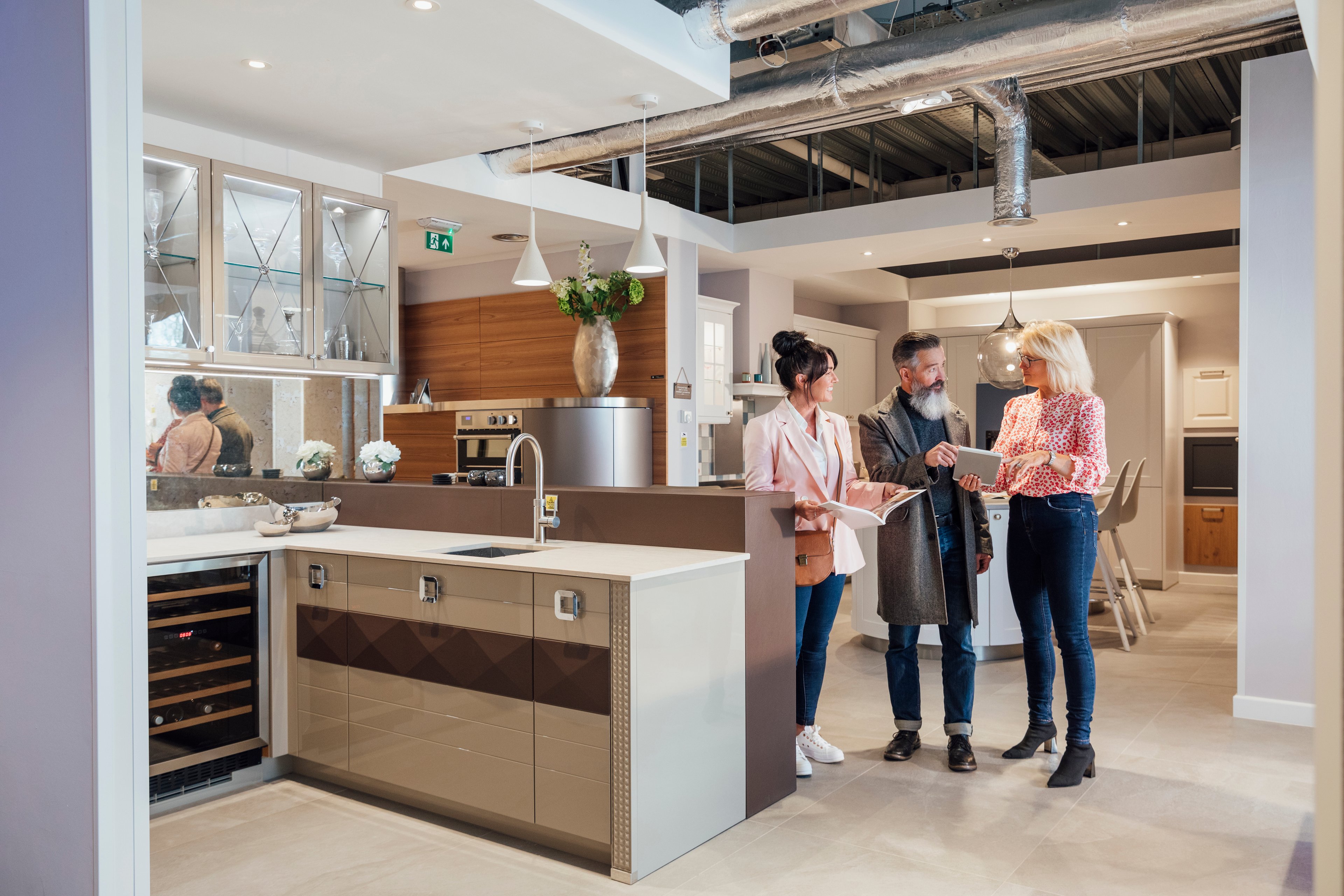 Couple talking with an interior designer at a kitchen design center.