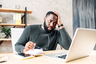 person feeling stressed looking at a laptop
