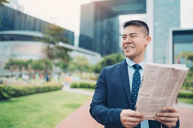 business newspaper suit outside happy