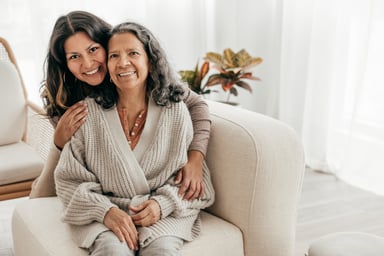 two people sitting on a couch and smiling